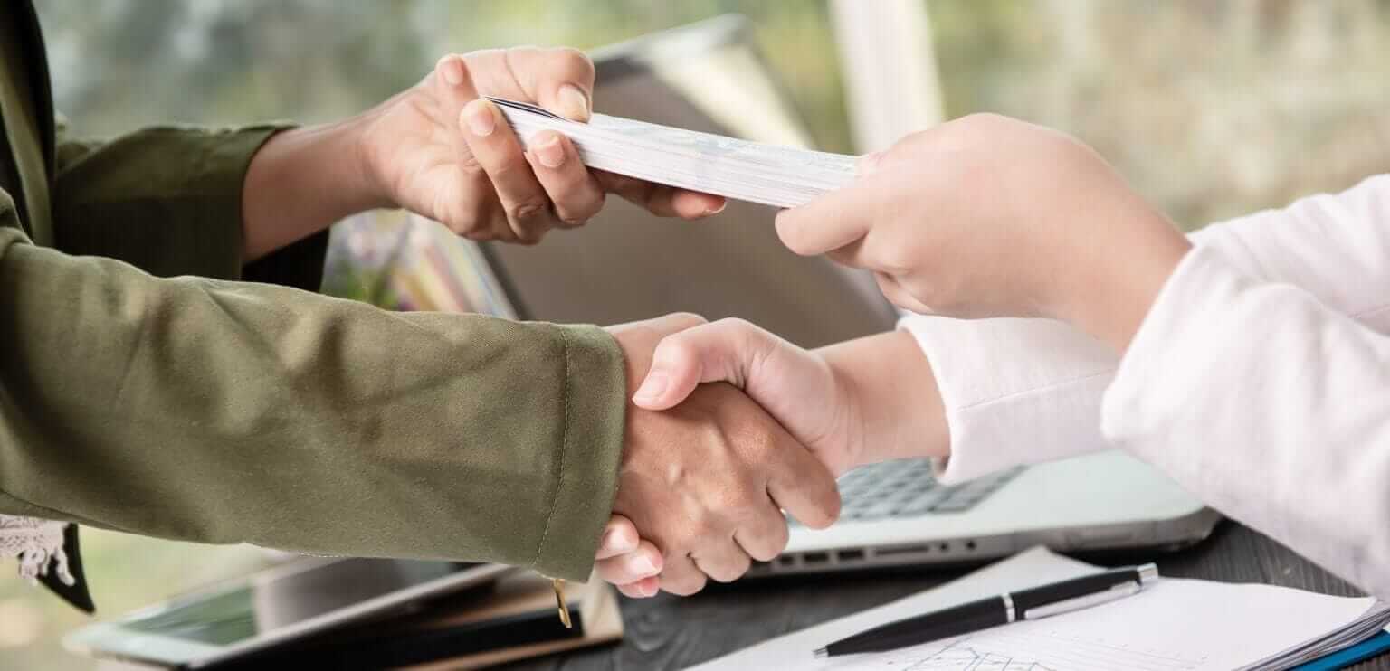 Persona firmando un contrato de crédito con un asesor financiero de coopfuturo