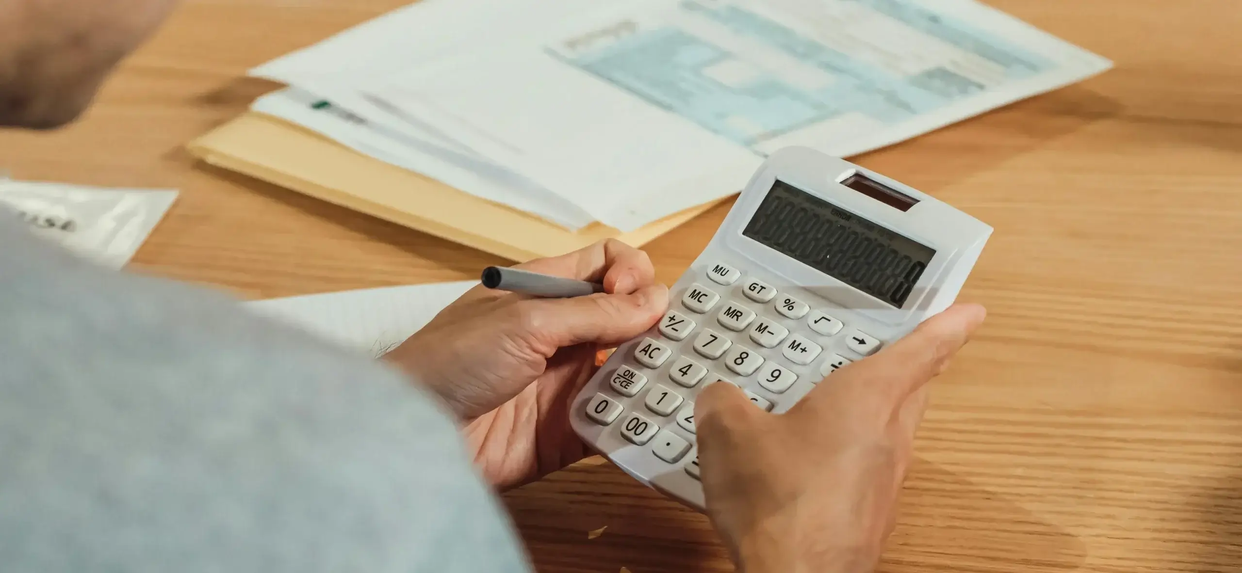 Estudiante universitario revisando su presupuesto en una calculadora.