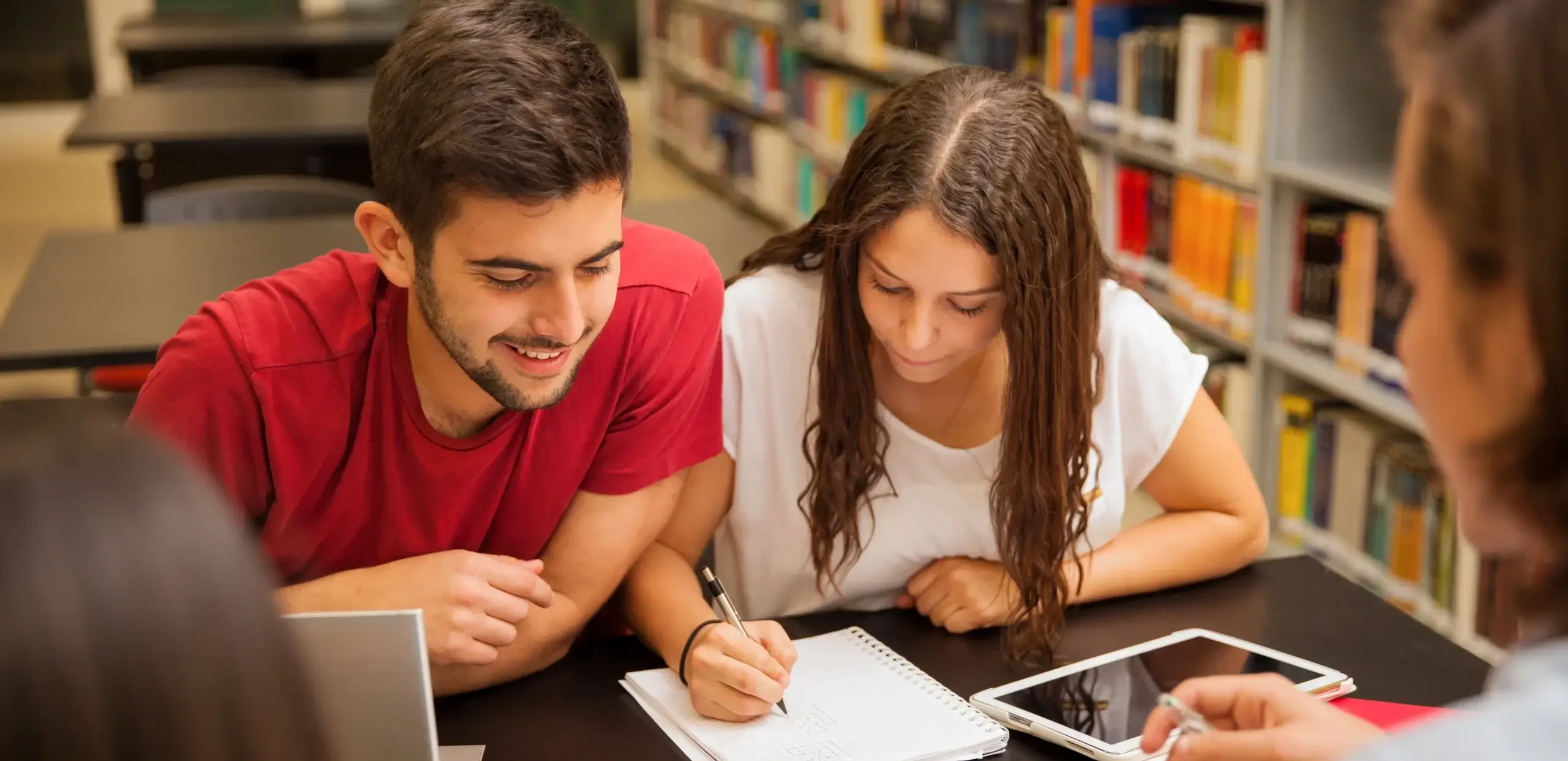 Persona joven estudiando con libros y representando superación financiera a través del estudio.